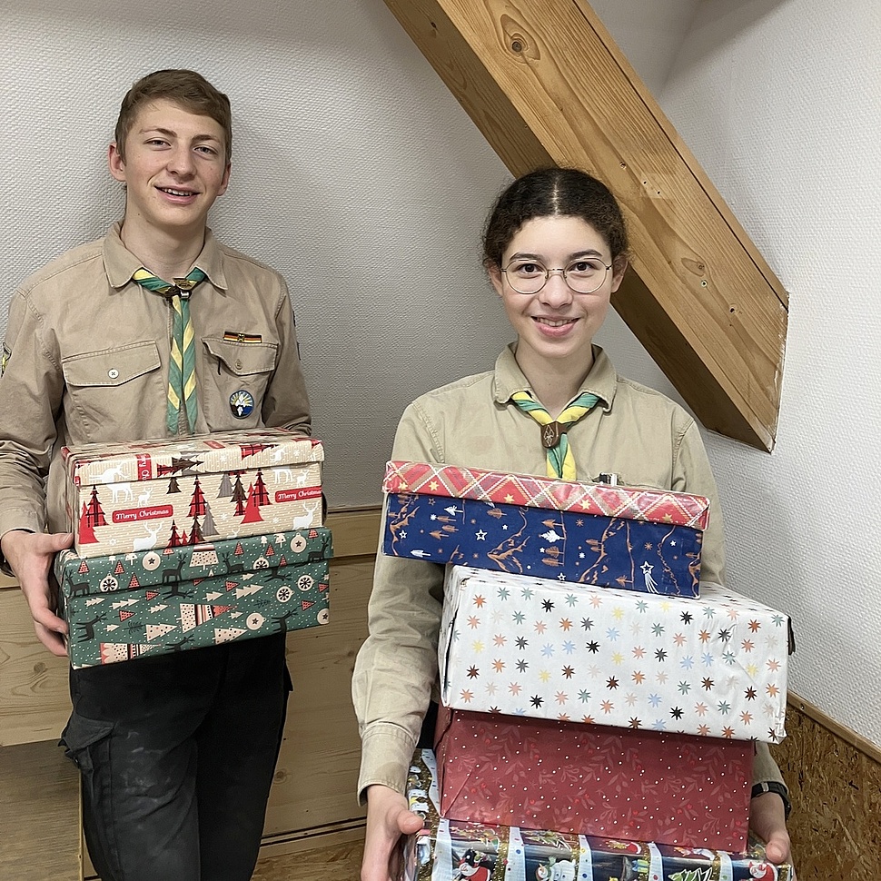 Pfadfinder tragen Kartons Gemeinsam packen wir Geschenkkartons